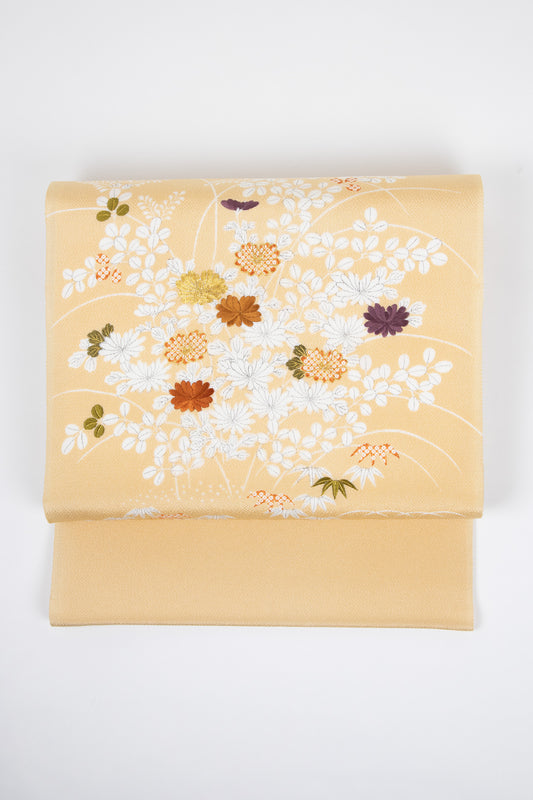 ベージュ色の御所解帯のお太鼓の写真