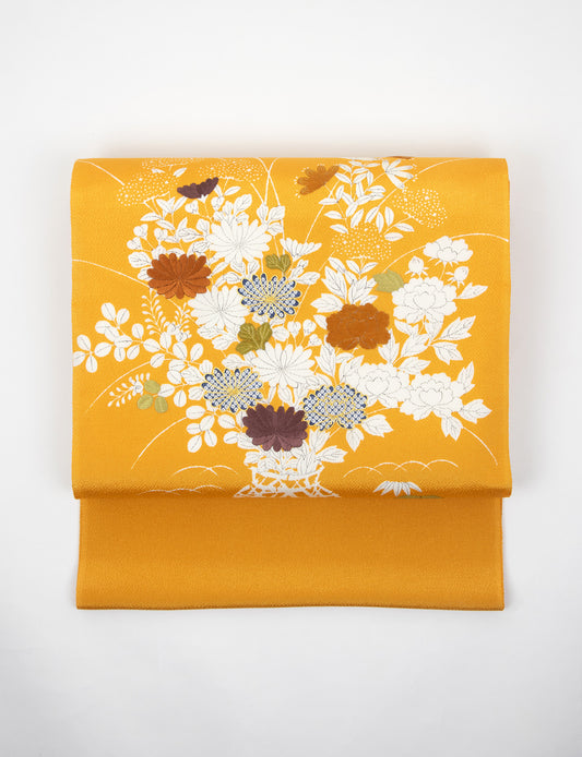 橙色の縮緬御所解帯のお太鼓の写真